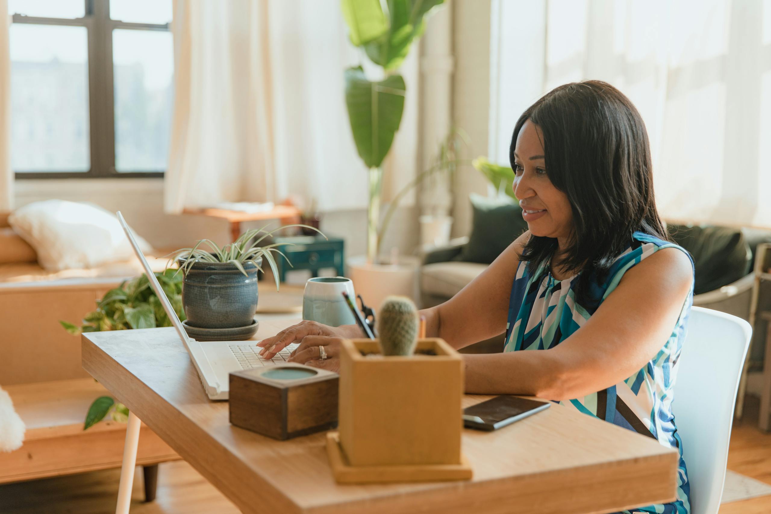 Woman Sitting at a Desk Using a Laptop